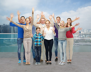 Image showing group of smiling people waving hands