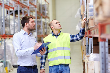 Image showing worker and businessmen with clipboard at warehouse