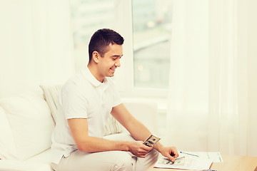 Image showing man with papers and calculator at home