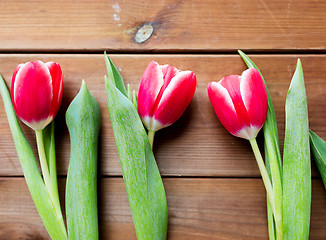 Image showing close up of red tulip flowers on wooden table