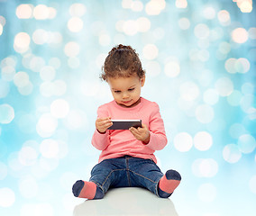 Image showing smiling little baby girl playing with smartphone