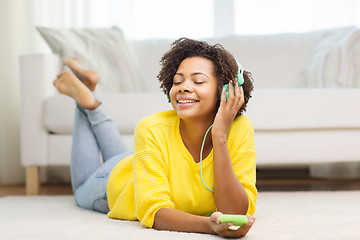 Image showing happy african woman with smartphone and headphones