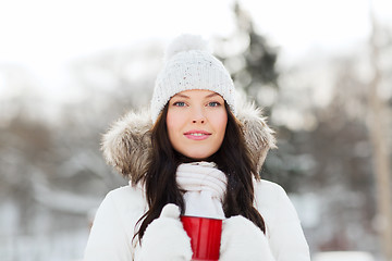 Image showing happy young woman with tea cup outdoors in winter