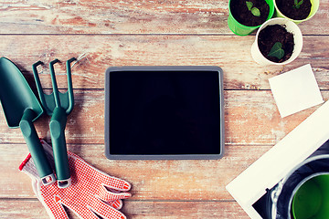 Image showing close up of tablet pc and garden tools on table