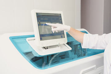 Image showing Lab tech loading samples into a chemistry analyzer