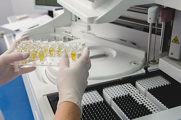 Image showing Lab tech loading samples into a chemistry analyzer