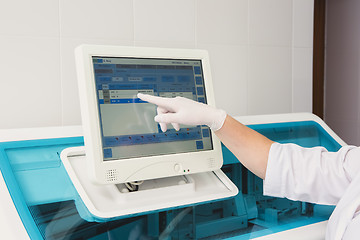 Image showing Lab tech loading samples into a chemistry analyzer