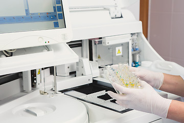 Image showing Lab tech loading samples into a chemistry analyzer