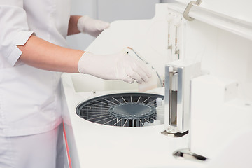 Image showing Lab tech loading samples into a chemistry analyzer