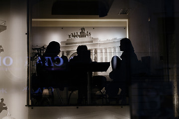 Image showing Silhouettes of people in the cafe