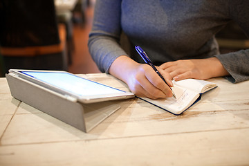 Image showing Woman taking down information in notebook