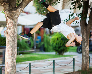 Image showing Young athlete doing extreme acrobatics outdoor