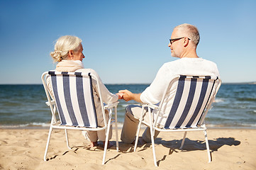 Image showing happy senior couple in chairs on summer beach