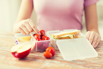 Image showing close up of woman with food in plastic container