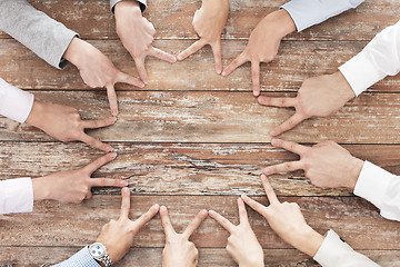Image showing close up of business team showing victory gesture