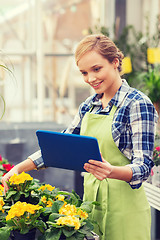 Image showing happy woman with tablet pc in greenhouse