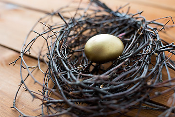 Image showing close up of golden easter egg in nest on wood