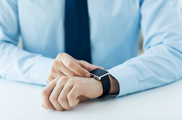 Image showing close up of male hands setting smart watch