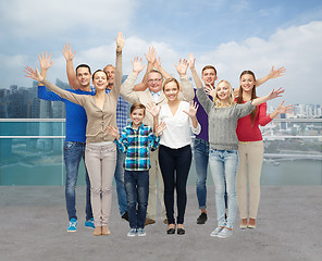 Image showing group of smiling people waving hands