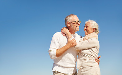 Image showing happy senior couple hugging outdoors