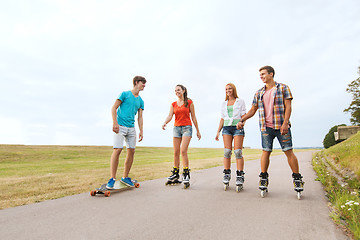 Image showing happy teenagers with rollerblades and longboards