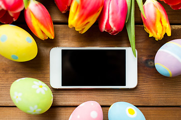 Image showing close up of easter eggs, flowers and smartphone