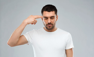 Image showing man making finger gun gesture over gray background