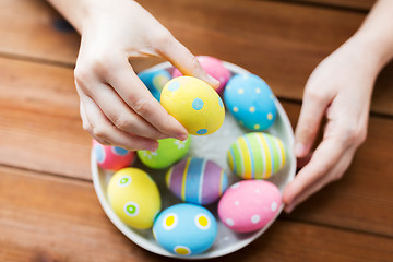 Image showing close up of woman hands with colored easter eggs