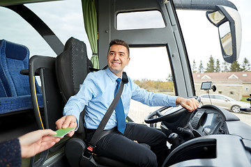 Image showing bus driver taking ticket or card from passenger