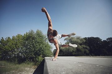 Image showing sporty young man jumping in summer park