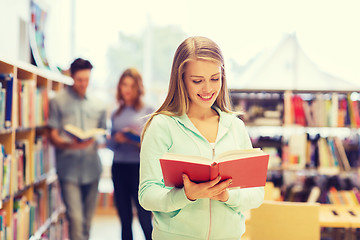 Image showing happy student girl or woman with book in library