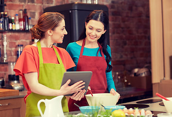 Image showing happy women with tablet pc cooking in kitchen