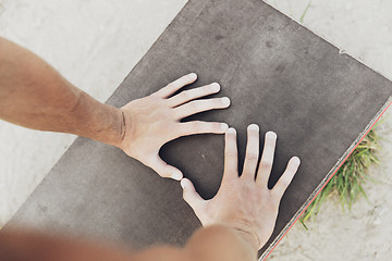 Image showing close up of man hands exercising on bench outdoors