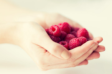 Image showing close up of woman hands holding raspberries