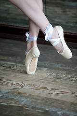 Image showing Dancing feet in ballet shoes on wooden floor