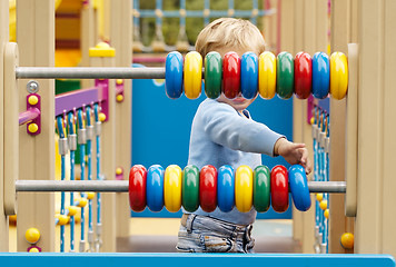 Image showing Little boy playing with an abacus