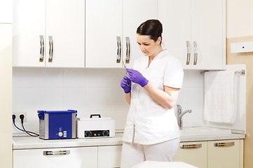 Image showing Cosmetician preapring tools for sterilization