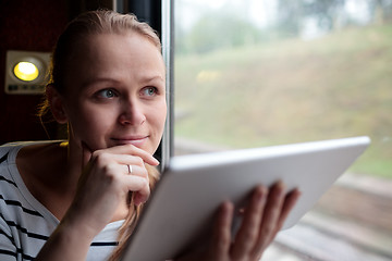 Image showing Smiling young woman traveling by train