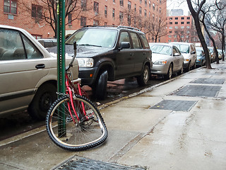 Image showing Broken bike tied to pole in New York