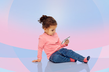 Image showing smiling little baby girl playing with smartphone