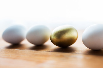 Image showing close up of golden and white easter eggs on wood