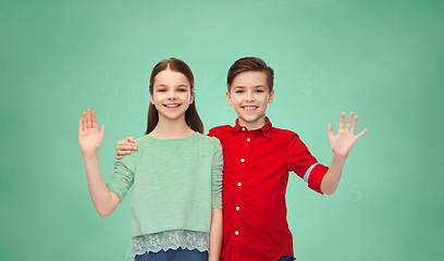 Image showing happy boy and girl waving hand