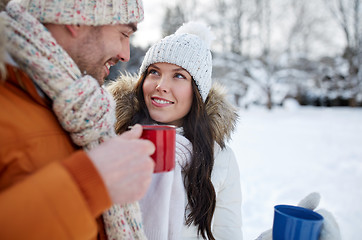 Image showing happy couple with tea cups over winter landscape