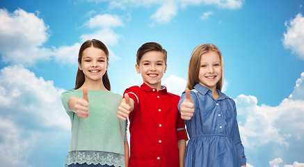 Image showing happy children showing thumbs up over blue sky