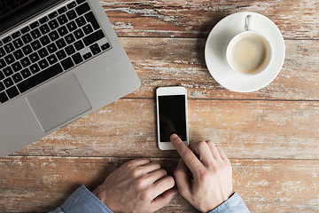 Image showing close up of hands with laptop and smartphone