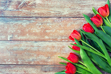 Image showing close up of red tulips on wooden background