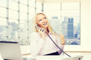 Image showing smiling businesswoman calling on telephone