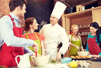 Image showing happy friends and chef cook baking in kitchen