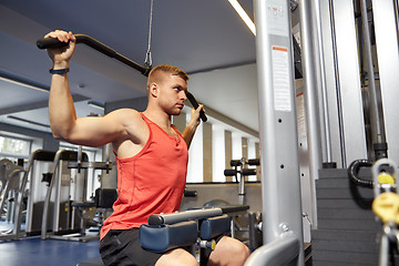 Image showing man flexing muscles on cable machine gym