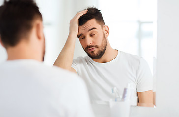 Image showing sleepy young man in front of mirror at bathroom